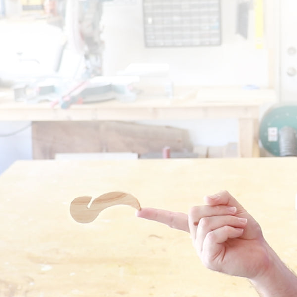 A skyhook toy, utilizes the principle of center of gravity to appear to defy gravity and balance on a finger